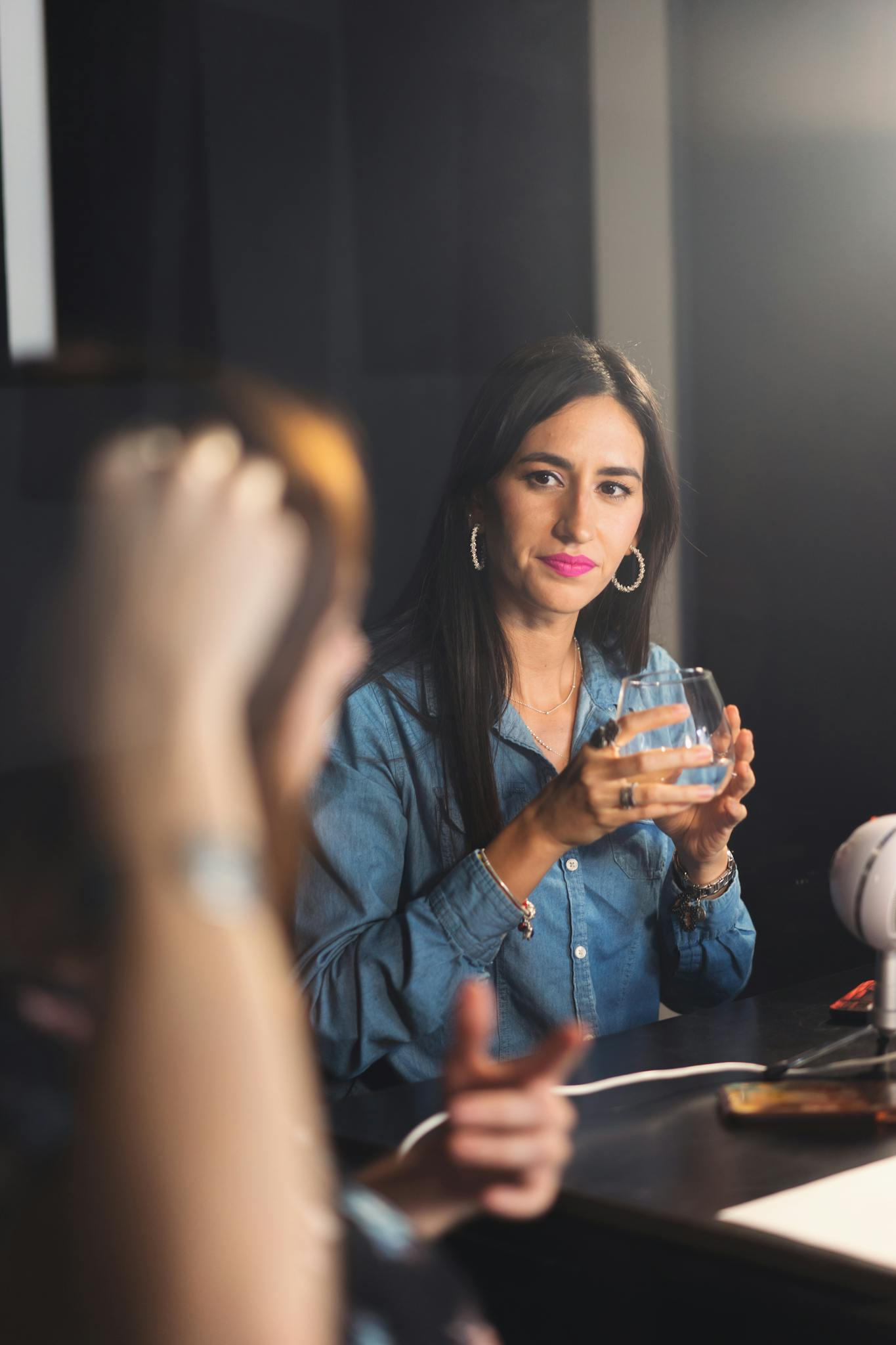 Two women enjoying a lively conversation during a podcast recording session.
